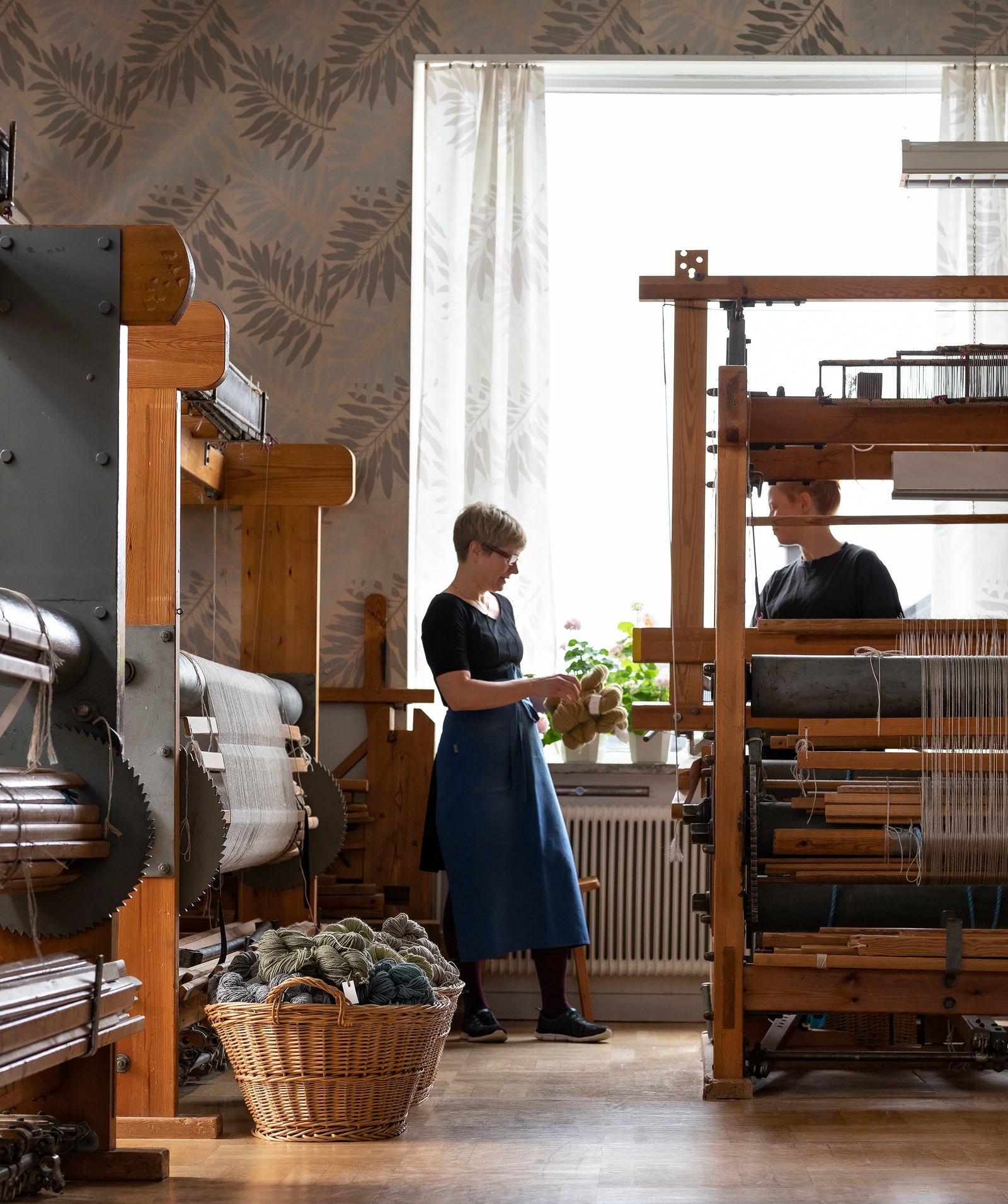 Art weavers working among wooden looms at the Märta Måås-Fjetterström studio in Båstad